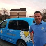 Man standing outside of a blue car