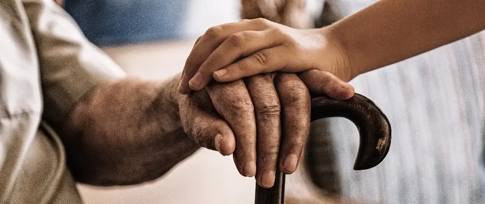 Carer placing hand on elderly person