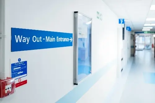 NHS hospital corridor with sign reading 'way out'