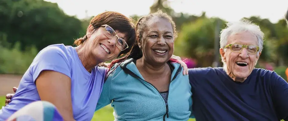 Older people exercising outside and laughing together