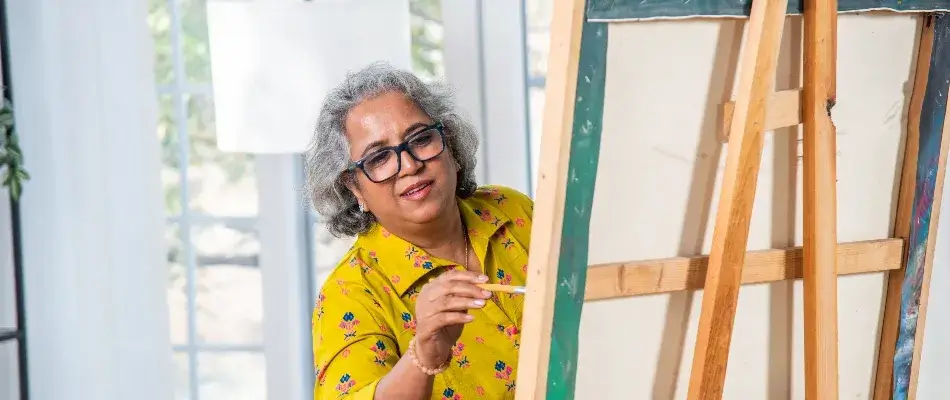 Older woman in yellow painting on canvas