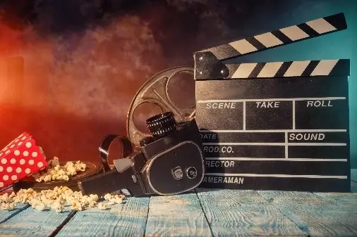 Retro clapper board with film roll and popcorn