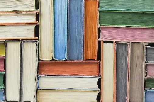Different coloured books stacked together
