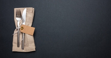 Fork and knife in a beige bundle against a black background